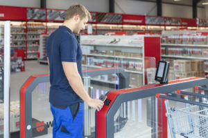 junger Mann vor digitalem Eingang in den Supermarkt