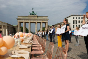 gedeckte Tafel und Demonstranten der Hochzeitsbranche