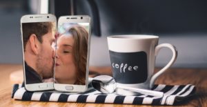 zwei Handys deren Besitzer sich im Display küssen