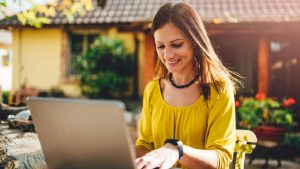 junge Frau am Laptop im Garten