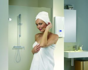 junge Frau in ein Handtuch gehüllt vor einer Dusche