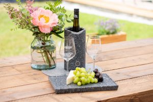 Weinkühler mit Flasche auf Gartentisch