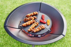 Spieße auf dem Grilleinsatz der gusseisernen Feuerschale