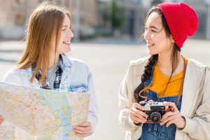 zwei junge Frauen mit Stadtplan und Kamera