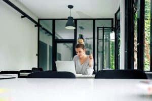 junge Frau sitzt am Laptop